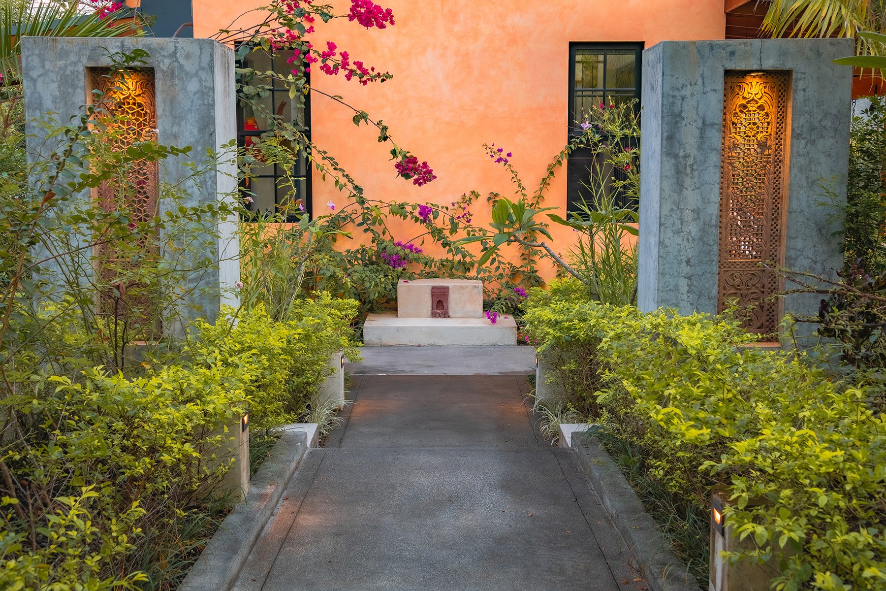 The entry walkway under bougainvillea at dusk